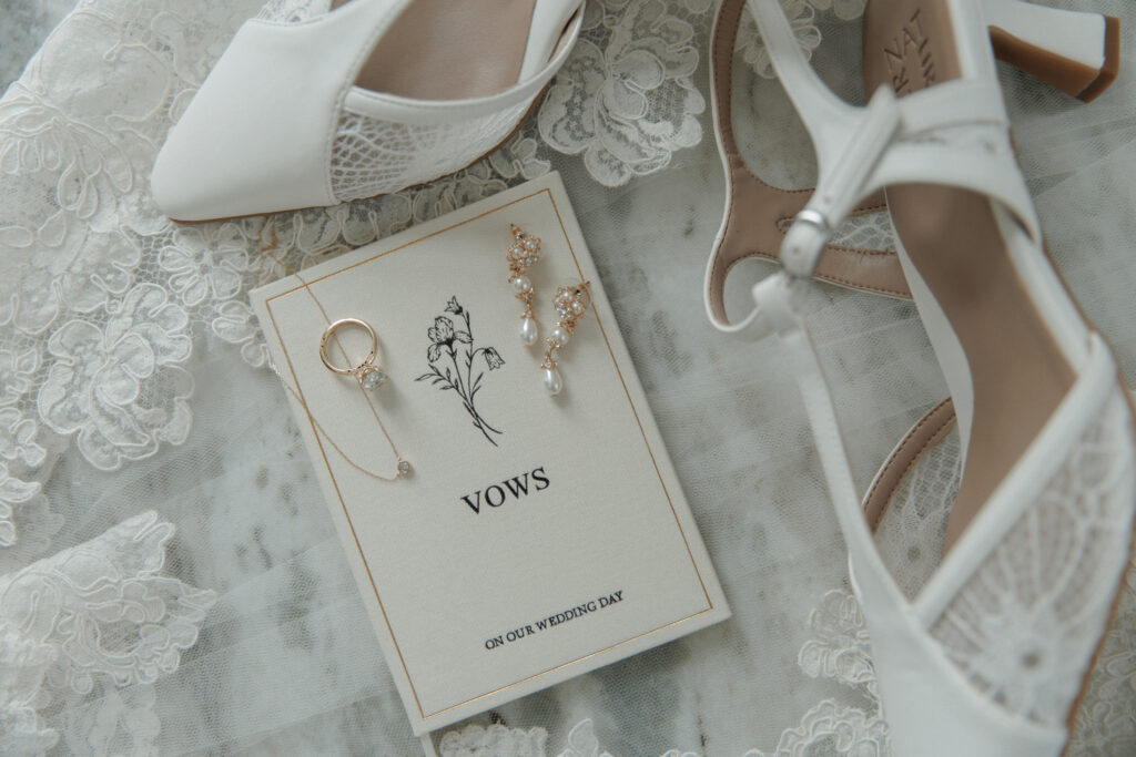 Wedding shoes, jewelry, and vow card arranged for AJ and Janel's wedding