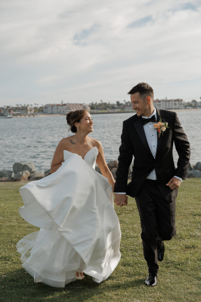 AJ and Janel walking together during their waterfront wedding portraits