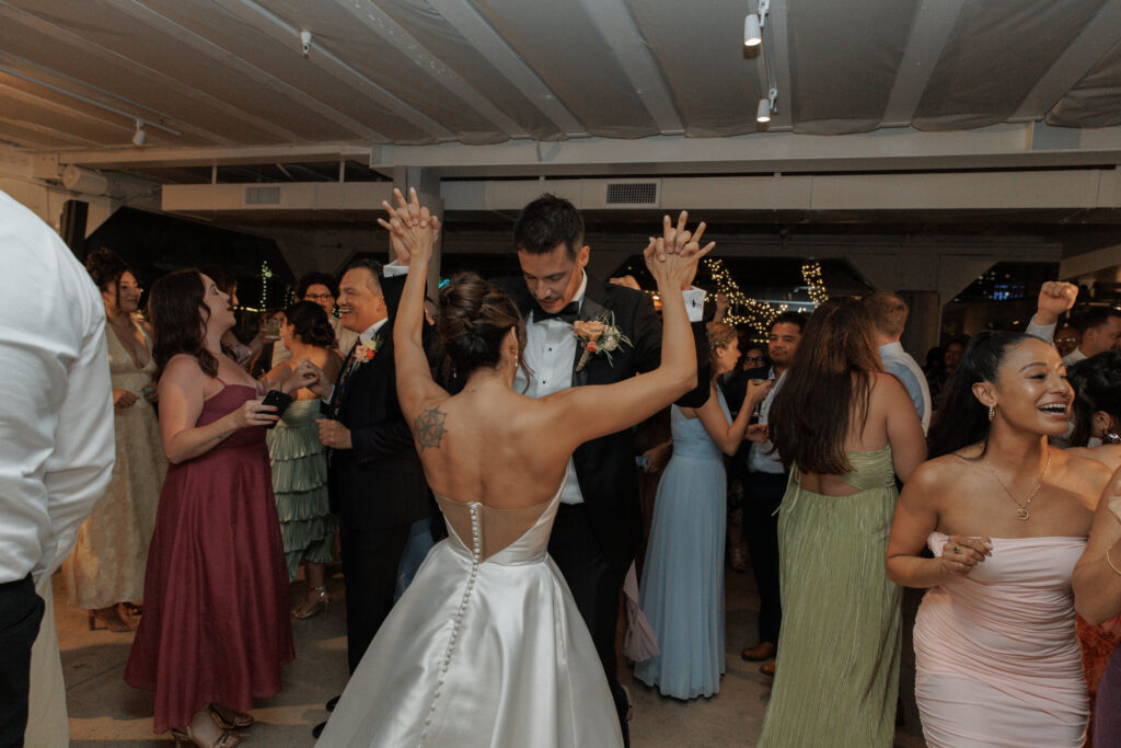 Newly wed couples Aj and Janel dancing together with guests.