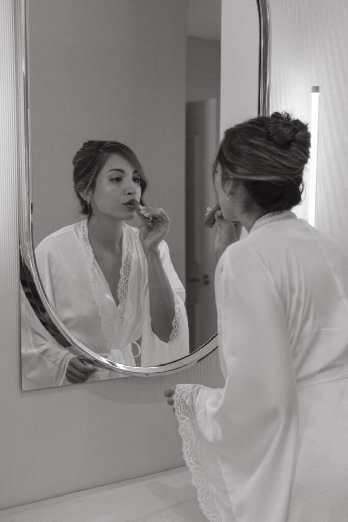 Bride having her makeup finished while getting ready for her wedding
