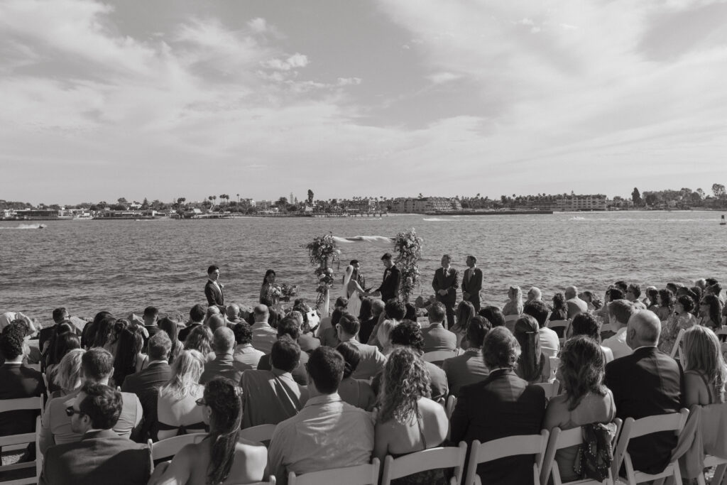 Guests seated for a waterfront wedding ceremony at Malibu Farm San Diego